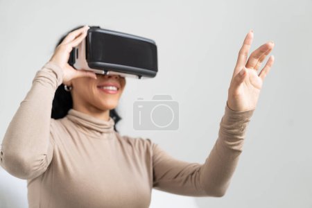 Photo for Young woman using virtual reality VR goggle at home for crucial online shopping experience. The virtual reality VR innovation optimized for female digital entertainment lifestyle. - Royalty Free Image
