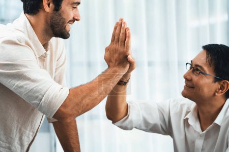 Photo for Diverse group of office employee worker high five after making agreement on strategic business marketing planning. Teamwork and positive attitude create productive and supportive workplace. Prudent - Royalty Free Image