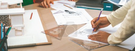 Photo for Cropped imaged of professional architect team discuss about interior material during project manager choose curtain material with house model and architectural equipment scatter around. Variegated. - Royalty Free Image
