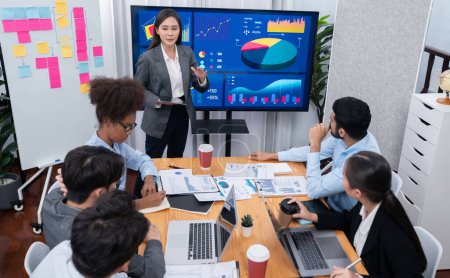 Photo for Young asian businesswoman presenting data analysis dashboard on TV screen in modern meeting. Business presentation with group of business people in conference room. Concord - Royalty Free Image