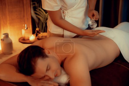 Photo for Masseur hands pouring aroma oil on man back. Masseuse prepare oil massage procedure for customer at spa salon in luxury resort. Aroma oil body massage therapy concept. Quiescent - Royalty Free Image