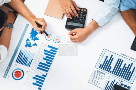 Photo for Diverse corporate audit team or company bookkeeper and accountant consultant calculate account expenses and income budget for tax refunds using calculators in top view busy workspace. Prudent - Royalty Free Image