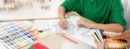 Photo for Professional architect drafts blueprint from project manager advice on table with house model, color palette and architectural equipment. Creative design concept. Focus on hand. Closeup. Variegated. - Royalty Free Image