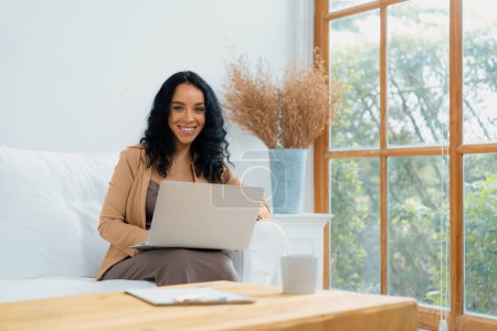 Photo for African-American woman using laptop computer for crucial work on internet. Secretary or online content writing working at home. - Royalty Free Image