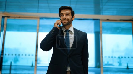 Photo for Project manager phone calling to colleague while standing in front of door with blue filter. Smart business man talking or discussing about marketing plan with business team by using phone. Exultant. - Royalty Free Image