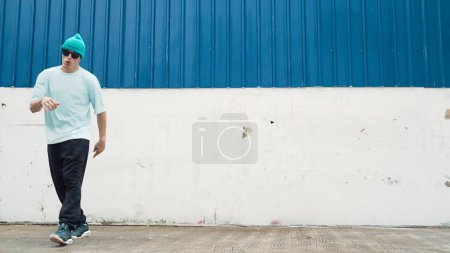 Photo for Motion shots of youthful hipster moving in lively groove at street. Caucasian break dance choreographer dancing in hip hop style. Energetic dancer perform b-boy dance. Outdoor sport 2024. Endeavor. - Royalty Free Image