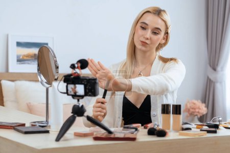 Photo for Young woman making beauty and cosmetic tutorial video content for social media. Beauty blogger smiles to camera while showing how to beauty care to audience or followers. Panorama Blithe - Royalty Free Image