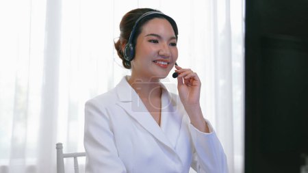 Photo for Businesswoman wearing vivancy headset working in office to support remote customer or colleague. Call center, telemarketing, customer support agent provide service on telephone video conference call - Royalty Free Image