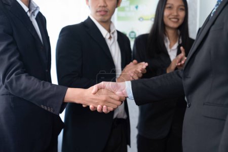 Téléchargez les photos : Les gens d'affaires asiatiques serrent la main après avoir conclu un accord fructueux dans la salle de réunion, serrant la main professionnelle avec des applaudissements dans la société. Charmante. - en image libre de droit