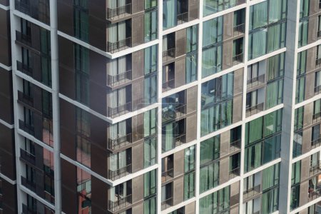 Photo for Window residential building apartment. Modern city skyscraper in day light. Apartment windows in modern skylines with day light. Many block of estate. Real estate. Closeup. Side view. Ornamented. - Royalty Free Image