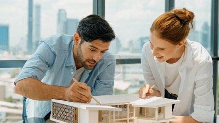 Photo for Cooperative architect engineer team working together to measure house model by using pencil. Successful caucasian interior designer team inspect architectural model construction. Design. Tracery - Royalty Free Image