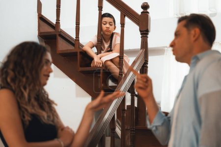 Photo for Stressed and unhappy young girl watch her parent arguing from the stair. Domestic violence at home and traumatic childhood develop to depression and anxiety. Unhealthy family concept. Synchronos - Royalty Free Image