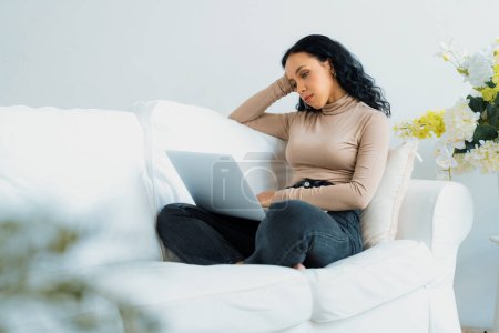 Téléchargez les photos : Jeune femme afro-américaine se sent déprimé tout en regardant le travail crucial dans l'ordinateur portable - en image libre de droit
