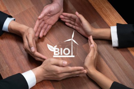Téléchargez les photos : Top View groupe de gens d'affaires formant cercle main ensemble autour de l'icône de biocarburant écologique sur la table de réunion. Des énergies alternatives avec la technologie Bio pour un avenir plus vert et durable. Charmante. - en image libre de droit
