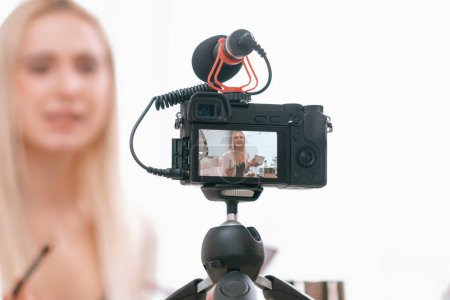 Photo for Blurred young woman making beauty and cosmetic tutorial video content for social media. Focused camera screen with beauty influencer showing how to apply beauty care to audience or followers. Blithe - Royalty Free Image