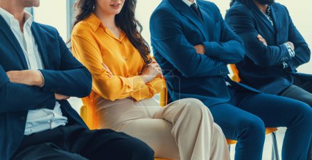 Diversity candidates siting while waiting for job interview with arm crossed in side view. Low section cropped image of business people smiling with confident. Modern waiting room. Intellectual.