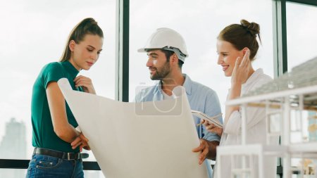 Photo for Professional architect engineer team talking, sharing, brainstorming about design while manager hold at project plan. Young architect holding plan while manager listen and point at plan. Tracery - Royalty Free Image