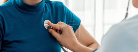 Photo for Patient attend doctors appointment at clinic or hospital office. Doctor examining and diagnosis symptoms while checking the patients pulse with stethoscope. Panorama Rigid - Royalty Free Image