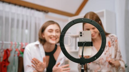 Photo for Two women influencer shoot live streaming vlog video review clothes prim social media or blog. Happy young girl with apparel studio lighting for marketing recording session broadcasting online. - Royalty Free Image