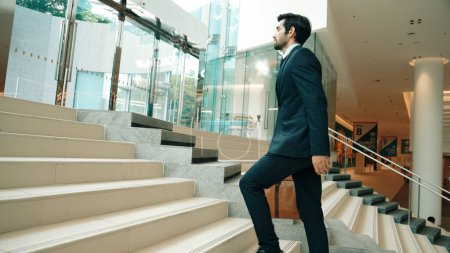 Photo for Professional business man going up the stairs. Successful man going up the stairs while explore a new thing. Represented traveling, getting a promotion, finding a new job, increasing skill. Exultant. - Royalty Free Image