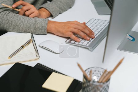 Photo for Cropped businessman working in casual day, using computer to search business marketing report for presentation with analyzing stock market exchange database on pc screen at modern office. Pecuniary. - Royalty Free Image