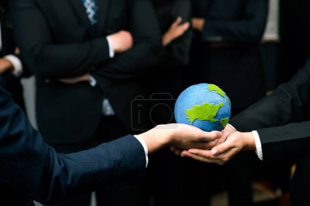 Téléchargez les photos : Top considérer les hommes d'affaires qui maintiennent la Terre en synergie en tant que team building pour utiliser l'éco-régulation pour la protection de l'environnement en réduisant les émissions de CO2 pour sauver la Terre. Charmante. - en image libre de droit