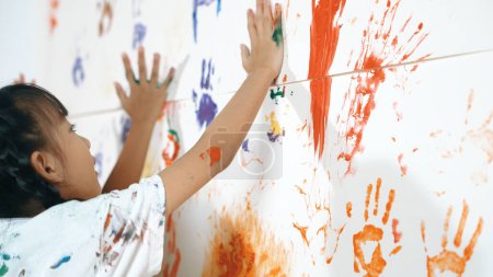 Photo for Close up of colorful stained wall was painted by student in art class. Funny asian girl playing with colorful watercolor with diverse children at messy room. Creative activity concept. Erudition. - Royalty Free Image