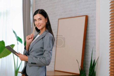 Photo for Portrait of happy and smiling female psychologist portrait sitting on arm chair in psychiatrist office or therapy room. Friendly and professional mental healthcare counselor and therapist. Blithe - Royalty Free Image