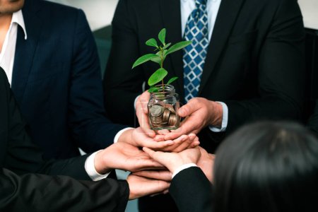 Photo for Business people holding money savings jar together in synergy filled with coin and growing plant for sustainable financial for retirement or eco subsidy investment for environment protection. Quaint - Royalty Free Image