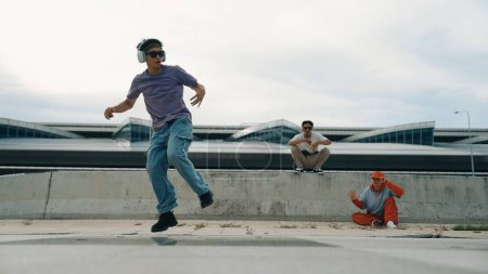 Photo for Group of skilled break dancer perform street dance with friend looking and cheering at him. Handsome hipster practice b boy dance at street while listening to music. Outdoor sport 2024. Sprightly. - Royalty Free Image