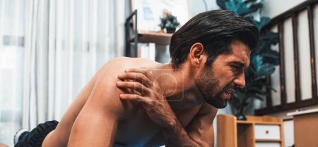 Photo for Athletic and sporty man suffer from exercise injury during home body workout exercise session. Painful ache from injured muscle accident during gaiety home exercise workout training concept. - Royalty Free Image