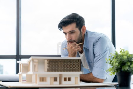 Photo for Smart civil architect engineer looking while planing design house construction with blueprint, house model and architectural equipment. Designer measuring and inspecting house model. Design. Tracery. - Royalty Free Image