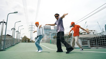 Photo for Group of professional break dancer dancing together or moving to hip hop music. Low angle camera of happy hipster team moving footstep and pose at camera. Crossing arm. Outdoor sport 2024. Sprightly. - Royalty Free Image