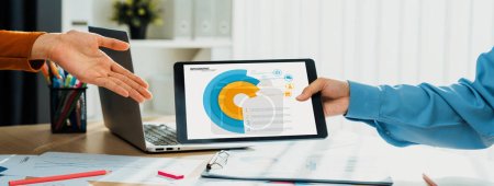 Photo for Startup company employee working together using tablet analyzing BI dashboard paper on financial data report and planning strategic marketing for business success in panorama banner. Synergic - Royalty Free Image