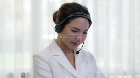 Photo for Businesswoman wearing headset working in office to support remote customer or colleague. Frustrated and tired call center customer support agent facing problem on providing vivancy service - Royalty Free Image