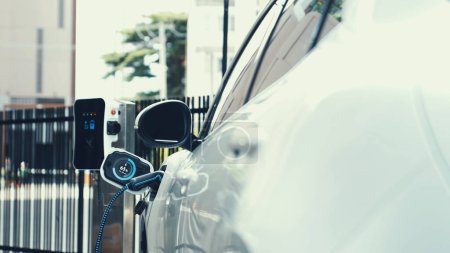 Téléchargez les photos : Recharge de voiture électrique avec chargeur EV à l'utilisation futuriste du parking de la station de charge afficher l'hologramme d'état de la batterie pour la voiture rechargeable EV en utilisant une énergie alternative et durable. - en image libre de droit