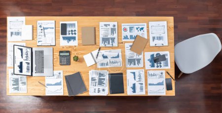 Photo for Panoramic top view data analysis dashboard paper on wooden table in meeting room. Paperwork show analytic graph and chart, market trend indication for strategic business investment insights.Meticulous - Royalty Free Image