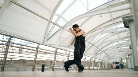 Photo for Skilled handsome hipster perform street dancing at narrow corridor. Professional hip hop dancer show b-boy step at corridor at urban city while wearing stylish cloth. Outdoor sport 2024. Sprightly. - Royalty Free Image