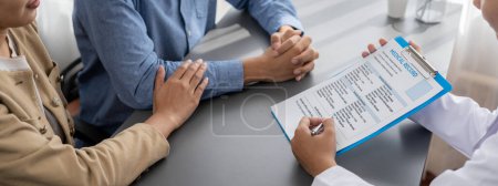 Photo for Doctor providing compassionate healthcare consultation while young couple patient holding hand, comfort each other after infertile report. Reproductive and medical fertility consulting. Neoteric - Royalty Free Image
