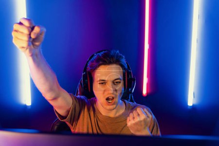 Photo for Host channel of gaming smart streamer playing online game to be winner, wearing headphone with viewers live steaming on media social online for selected team competition at neon light room. Pecuniary. - Royalty Free Image