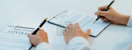 Photo for Business executive signing contract agreement document on the bale with the help from company attorney or lawyer service in law firm office. Business investing and finalizing legal processing. Shrewd - Royalty Free Image