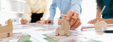 Photo for Professional architect engineer team discussion about architectural project on meeting table with wooden block and blueprint scatter around. Design and cooperate concept. Closeup. Delineation. - Royalty Free Image