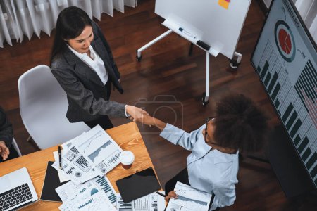 Photo for Top view diverse coworker celebrate with handshake and teamwork in corporate workplace. Happy business people handshaking after successful meeting or business presentation on data analysis. Concord - Royalty Free Image