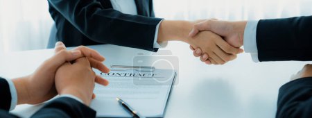Photo for Two business executive shake hand in boardroom, sealing agreement merging two company. Handshake symbolize business partnership and cooperation. Corporate acquisition and merger concept. Shrewd - Royalty Free Image