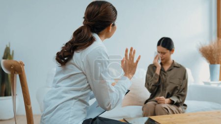 Photo for Sad PTSD woman patient in therapy for mental health with psychologist, depression or grief after life failure. Frustrated trauma young woman talking to vivancy psychologist about emotion in clinic - Royalty Free Image