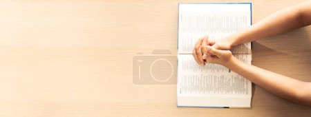Photo for Female prayer folding hand on holy bible book on wooden church table. Concept of hope, religion, faith, christianity praying for love and god blessing. Warm and brown background.Top view. Burgeoning. - Royalty Free Image