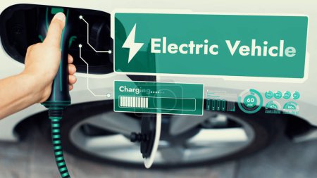 Photo for Top view hand insert EV charger and recharge electric car from charging station displaying futuristic battery status hologram. Smart sustainable clean energy. Peruse - Royalty Free Image