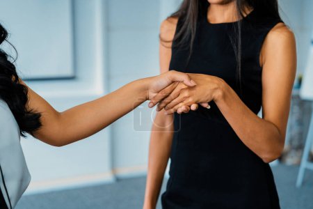 Téléchargez les photos : Deux jeunes femmes d'affaires asiatiques se serrent la main au bureau. Amis d'affaires et concept communautaire. uds - en image libre de droit