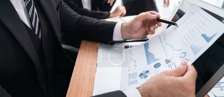 Photo for Diverse group of business analyst team analyzing financial data report paper on office table. Chart and graph dashboard by business intelligence analysis for strategic marketing planning Habiliment - Royalty Free Image