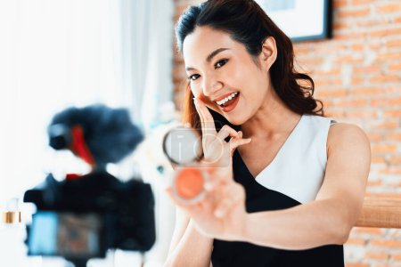 Foto de Asian Woman influencer shoot live streaming vlog video review makeup uttermost social media or blog. Chica joven feliz con iluminación de estudio de cosméticos para la sesión de grabación de marketing radiodifusión en línea - Imagen libre de derechos
